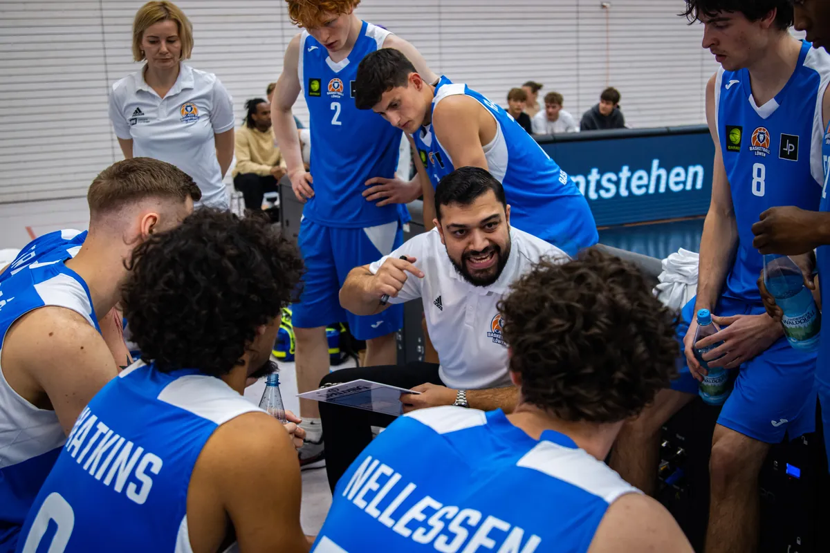 Trainer und Spieler der Basketball Löwen Erfurt besprechen sich in einer Auszeit an der Bank