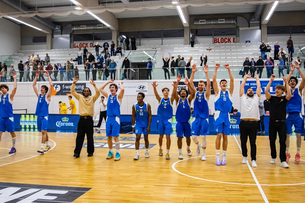 Spieler der Basketball Löwen Erfurt und Fans jubeln gemeinsam mit erhobenen Armen