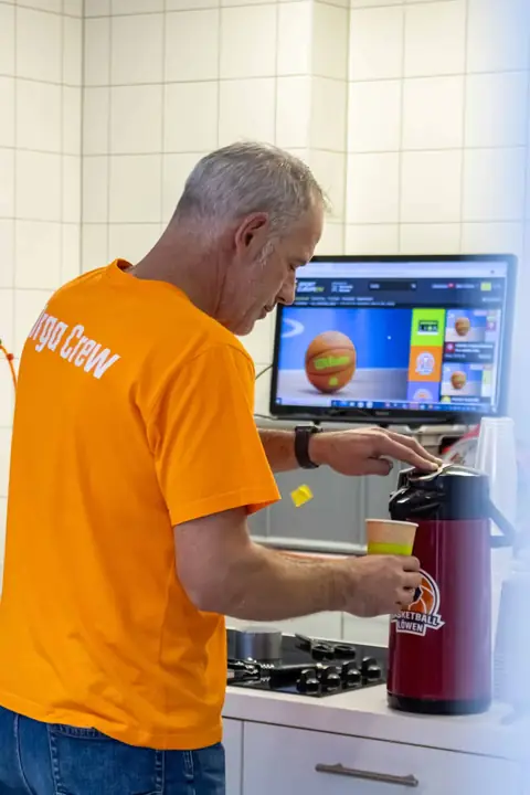 Ehrenamtlicher bereitet Getränke für das Team vor