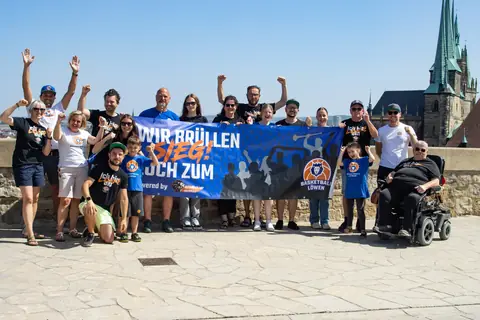 Fangruppe hinter dem Banner, einige mit erhobenen Armen