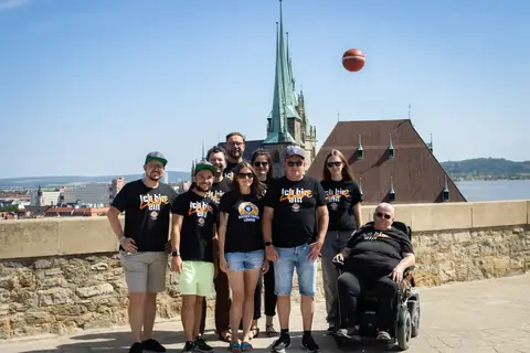 Fangruppe posiert, während ein Basketball in die Luft geworfen wird
