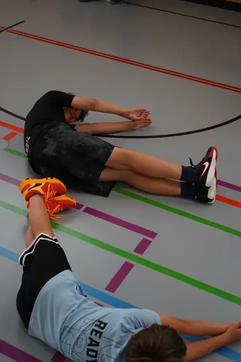 Teilnehmer beim Dehnen vor dem Training