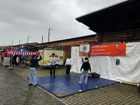Korbwerfen auf dem mobilen Spielfeld beim Kinderfest am Zughafen